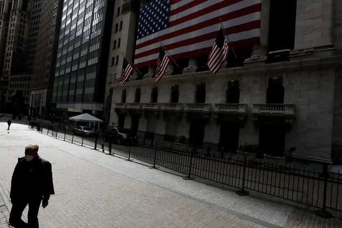 A lone man walks in front of the New York Stock Exchange in New York City on April 8th, 2020.
